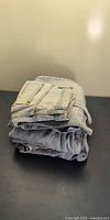 Stack of four folded light blue denim jeans