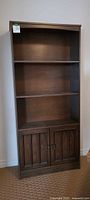 Full front view of bookcase showing open shelves and lower cabinet