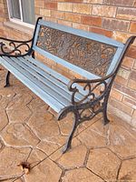 Full view of bench showing cast iron frame and blue wooden slats