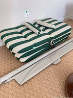 Stacked chaise cushion showing stripes and small cushions