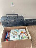 RCA stereo with speakers, Citizen boombox and box of media