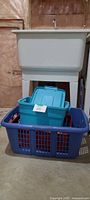 overall lot showing blue laundry basket with items nested inside