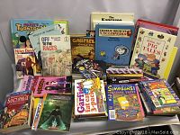 Full view of the lot showing the approximately 50 children's books stacked and arranged, displaying titles such as Garfield, Nancy Drew, Goosebumps, Snoopy, Mickey's Toon Town Library, and others.