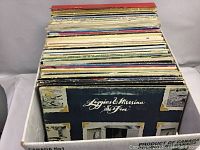 Side view showing a stack of approximately 60 LP records in their sleeves, with visible wear on some covers. Record on the bottom in clear view is Loggins & Messina 'So Fine'.
