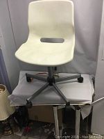 Front view of white IKEA office chair on five-wheel metal base showing some dirt marks on seat and backrest.