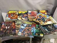 Lot of various comic books and comic magazines laid out on a table showing titles and characters like Conan, Batman, Spider-Man, JLA, and Marvel Wizard magazines.