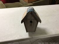 Front view of the vintage wooden wren bird house showing circular entrance hole and text above it.