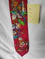 Full view of red necktie displaying characters and cottage scene