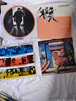 Group shot of four album covers on white sheet
