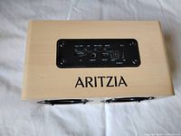 Top view showing ARITZIA logo and control panel with ports and buttons