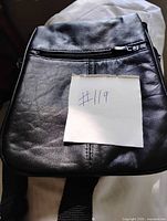 front view of black leather bag showing front zipper pocket
