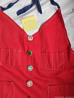 front view of red bib vest showing buttons and pockets