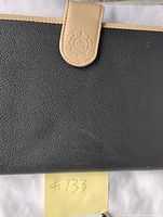 Close view of day planner front showing textured surface and tan tab with embossed logo