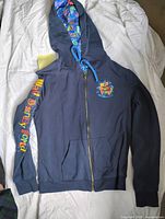 Full view of navy outer side showing graphics, zipper, pocket and sleeve print