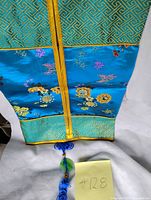 Full view of blue embroidered flat pouch showing floral motifs and dimensions