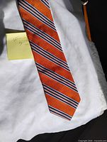 Full view of orange silk tie with striped pattern