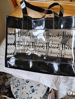 Front view of Harrods clear PVC tote showing overall design, logo pattern and handles