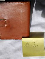 Front exterior of brown leather wallet showing debossed Holt Renfrew branding