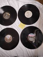 Four loose vinyl records displayed label-side up