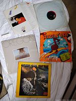 Four LPs laid out showing jackets and one loose record
