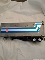 Left side view showing blue stripe decal and Autobot logo
