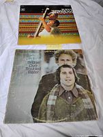 Both album covers laid out on white cloth