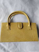 front view of yellow handbag showing swirl texture and handles