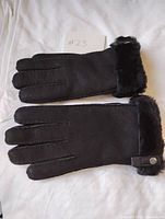Both gloves laid flat showing exterior suede, fur cuffs, strap snap