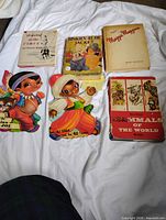 All six books laid out on bed