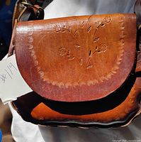 Front view of purse showing floral tooling and flap
