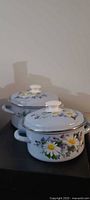 Two enamel stockpots with lids showing exterior floral pattern