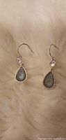 Pair of silver-tone drop earrings with grey teardrop stones and clear rhinestone accents