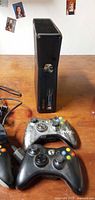 Front view of Microsoft Xbox 360 S console with two controllers