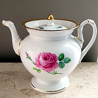 Full view of teapot showing rose motif, spout, handle and footed base
