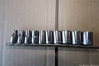 Front view of twelve 1/4" drive metric sockets on rail