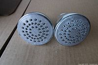 Front view of both Moen shower heads showing spray faces