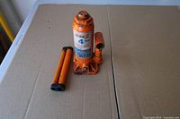 Front view orange 4-ton bottle jack with two handle sections