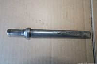 Full view of the steel chisel laid on cardboard