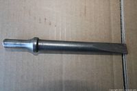 Steel chisel full view on cardboard background