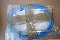 Sealed blue A/C hose coiled in plastic with brass ends visible