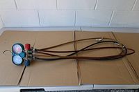 Full view of manifold gauge set with three hoses laid out