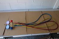 Manifold gauge set with hoses laid out on table