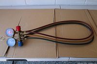 Full view of manifold gauges with attached hoses