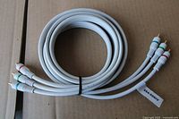 Coiled white component audio video RCA cable showing connectors