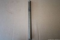 Full view of brass drift punch lying vertically on cardboard