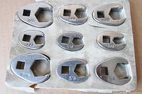 Nine chrome crowfoot wrenches on cardboard backing showing all SAE sizes