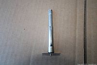 Full view of metal depth gauge showing scale and base