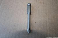 Phillips screwdriver bit front view on cardboard background