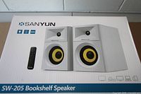 Front view of sealed Sanyun SW-205 speaker box showing product image, brand and model
