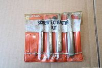 Front view of KD Tools screw extractor kit showing four metal extractors in red vinyl pouch